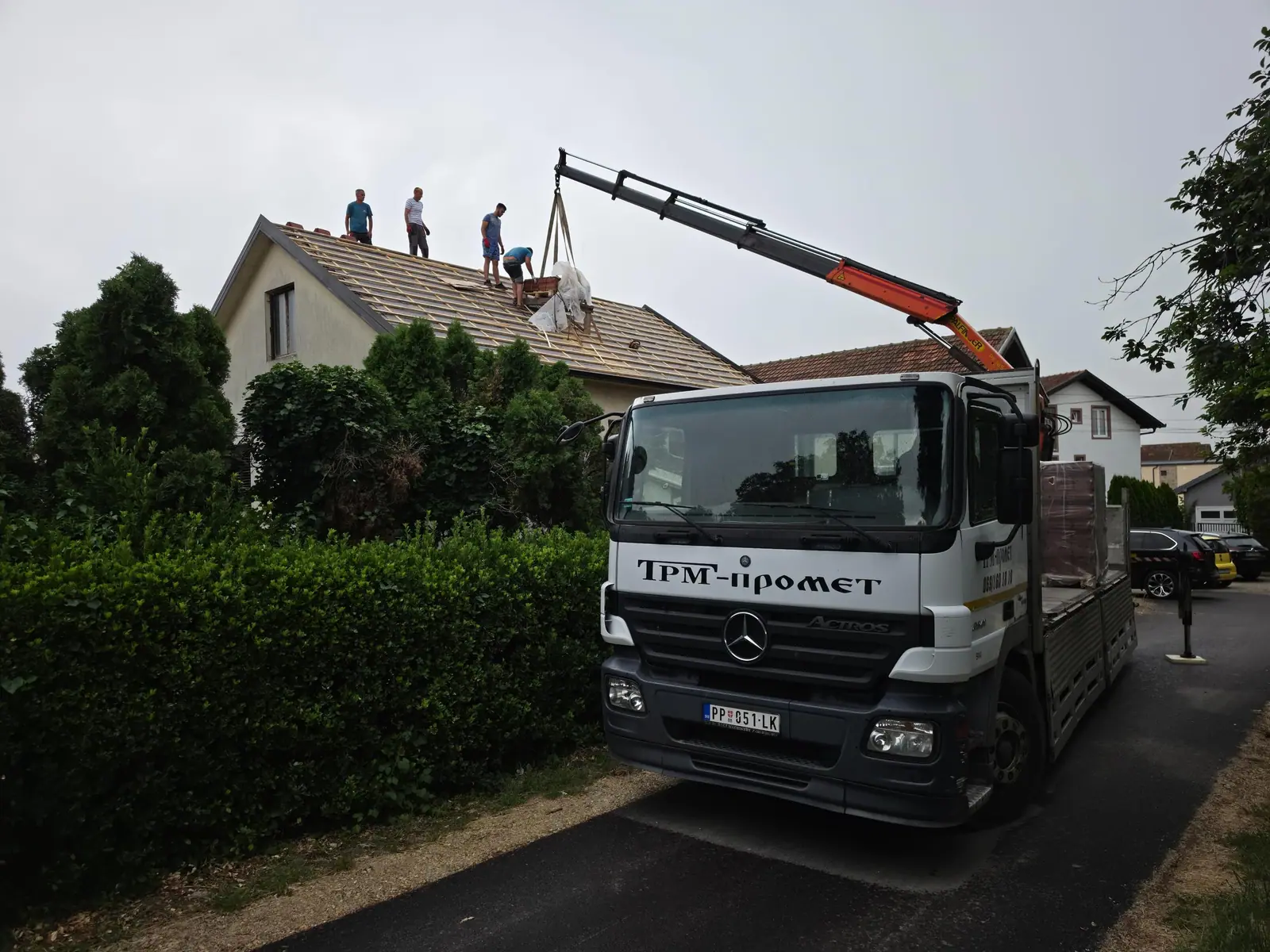 TRM kamion kranom podiže crep na krov kuće